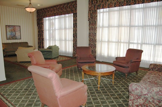 Fairmont Apartments Lounge room with red chairs and green rugs